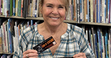Ann Wilson holding up award-winning bookmarks